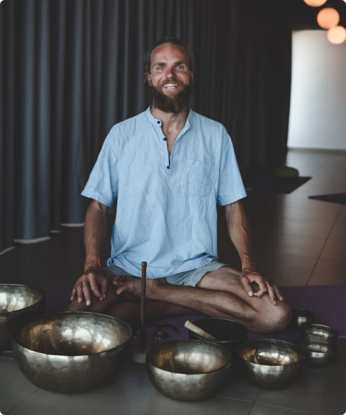 Michaël Bijker sitting with metal mixing bowls to create music